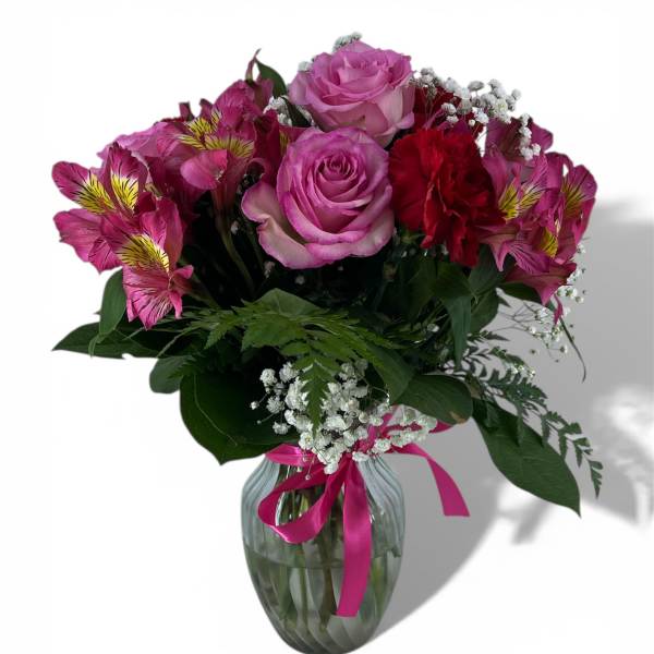 Pink and red mixed bouquet in a glass vase with a ribbon