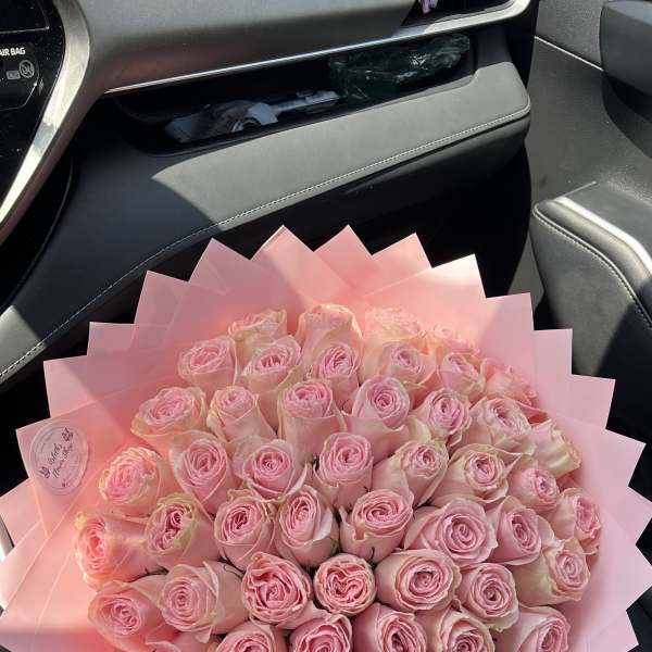 Large bouquet of pink roses wrapped in pink paper