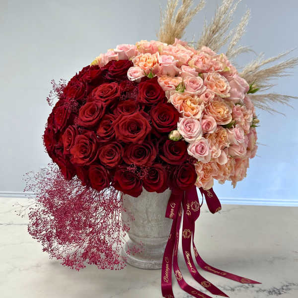 Large bouquet of red and blush roses in a silver vase
