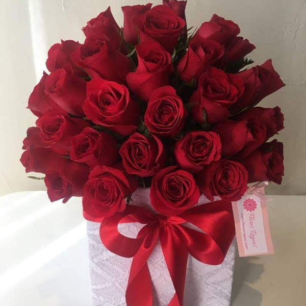 Bouquet of red roses in a white box with a red ribbon