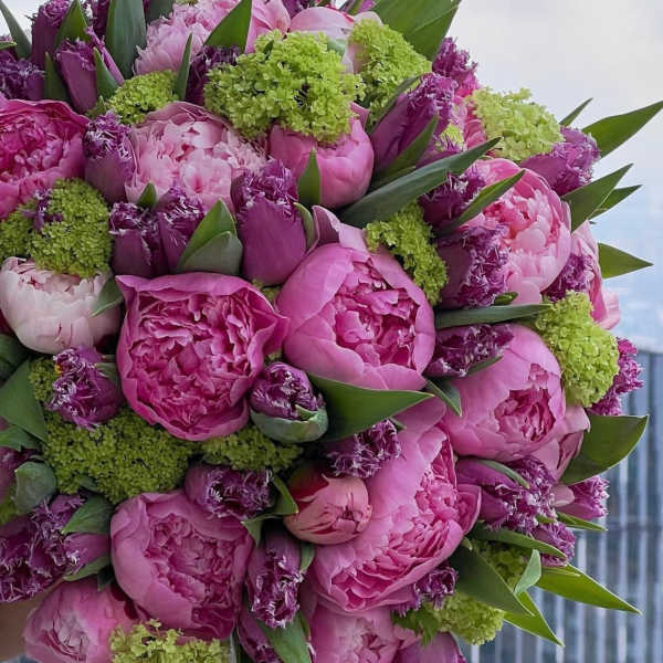 Bouquet of pink peonies and purple flowers with green accents