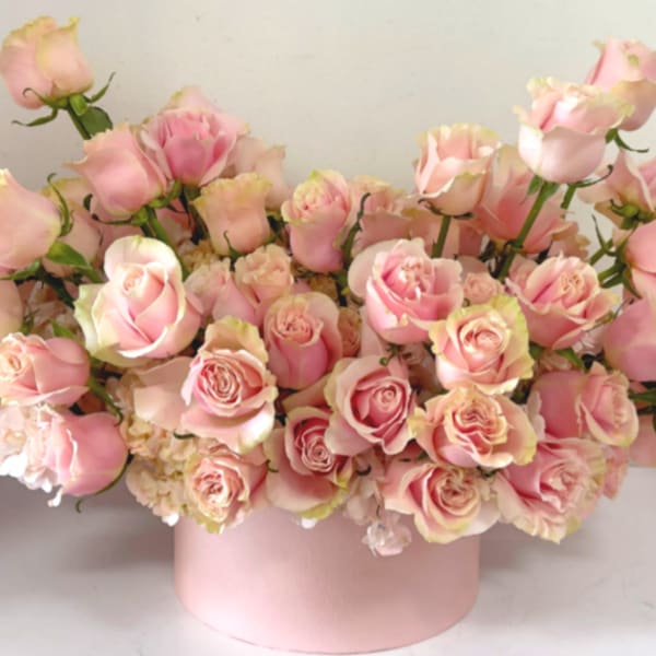 Pink roses arranged in a round pink box