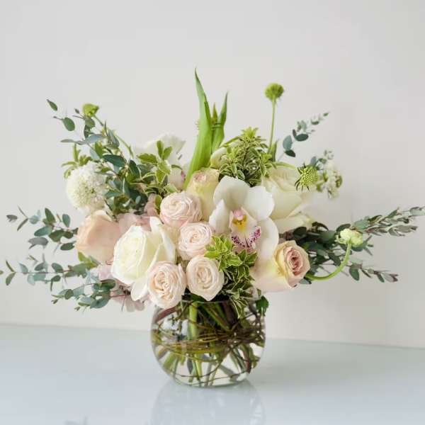 Blush and white floral arrangement in a clear glass vase