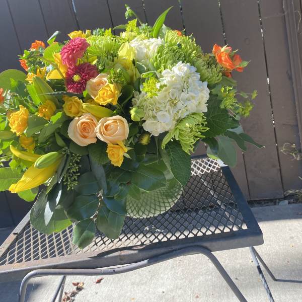 Mixed bouquet with yellow lilies, roses, and white hydrangeas in a vase