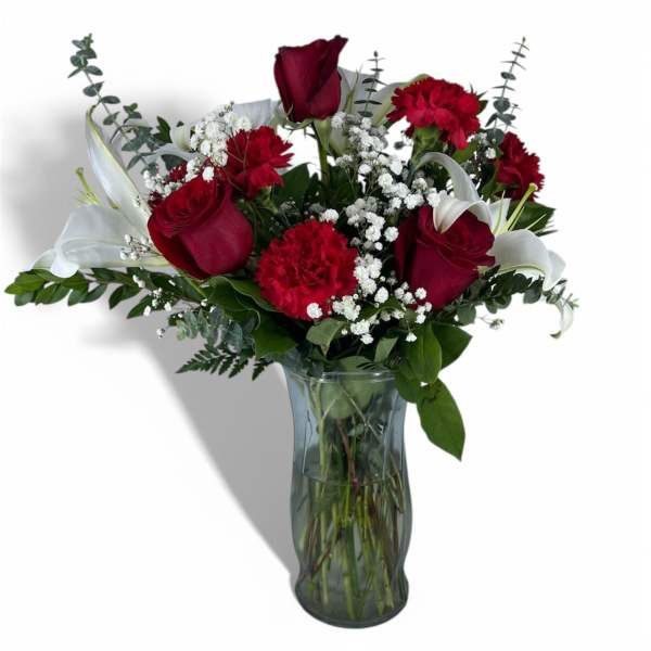 Red roses and carnations with white lilies in a glass vase