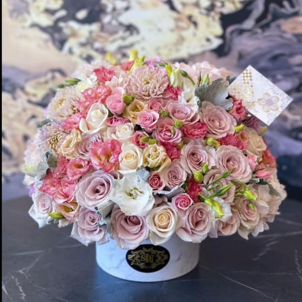 Round bouquet of pink and white roses in a white hat box