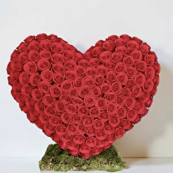 Heart-shaped arrangement of red roses on a moss base