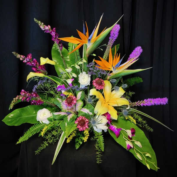 Tropical floral arrangement with bird-of-paradise, lilies, and purple spikes