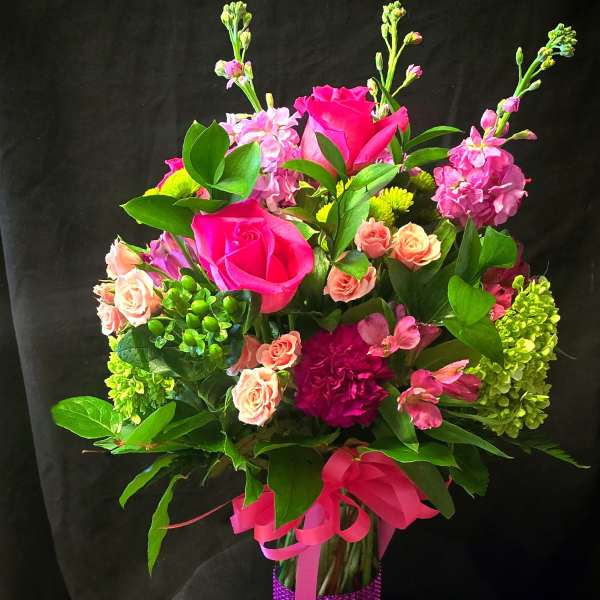 Pink and peach flower bouquet in a purple wrapped vase