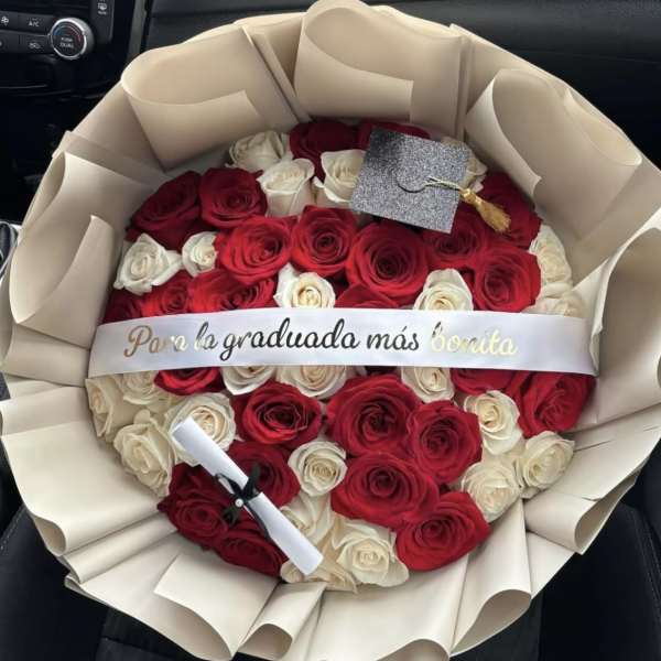 Bouquet of red and white roses wrapped in cream paper with a graduation ribbon