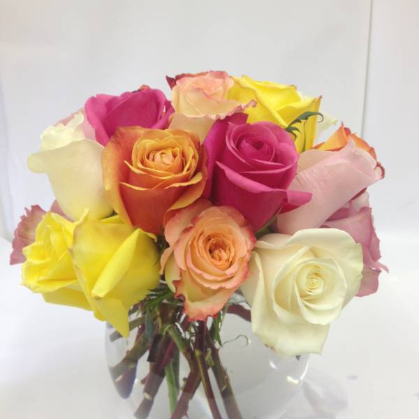 Bouquet of multicolored roses in a clear glass vase