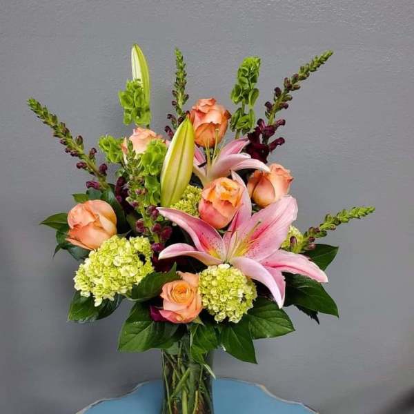Pink lilies and peach roses in a glass vase