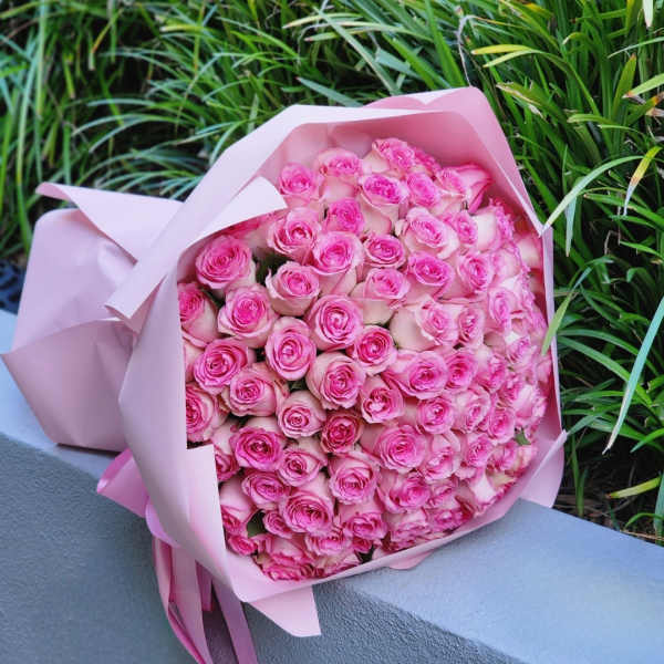 Bouquet of pink roses wrapped in pale pink paper