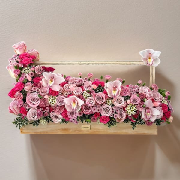 Pink rose and orchid arrangement in a rectangular wooden box