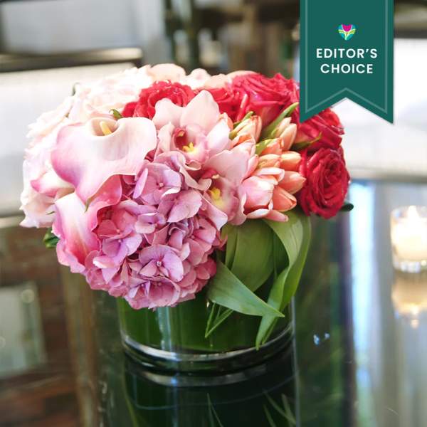 Pink and red floral arrangement in a glass vase
