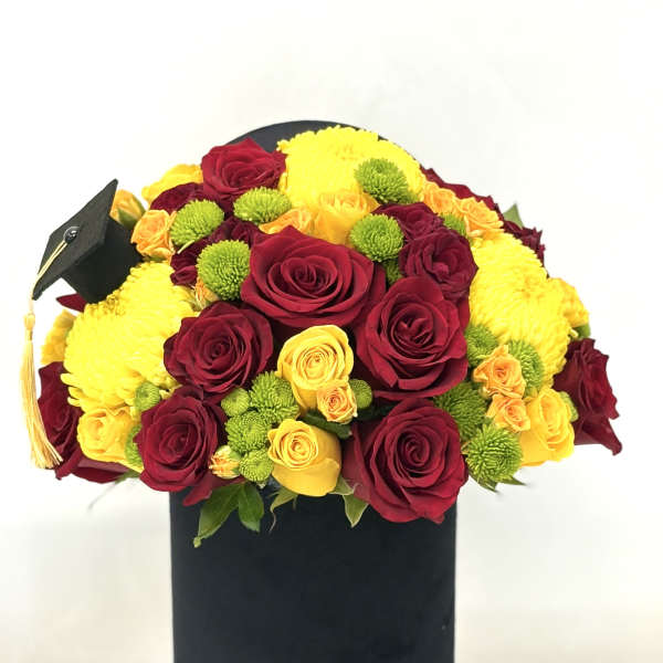 Bouquet of red and yellow roses with green button mums in a black box