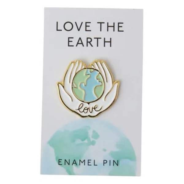 Enamel pin on a card with hands holding the Earth and the words Love the Earth