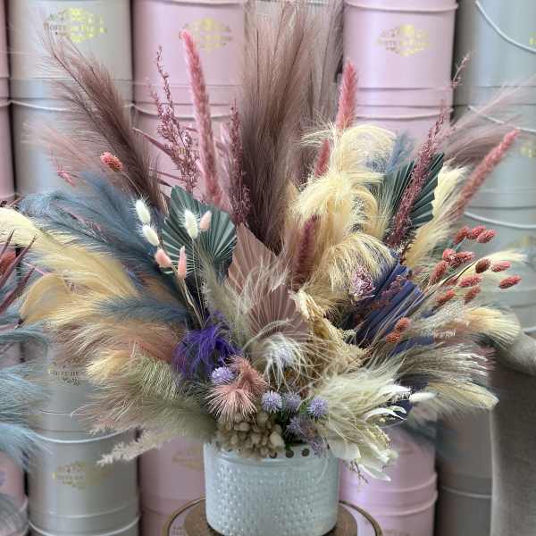 Pastel dried floral arrangement in a light blue vase