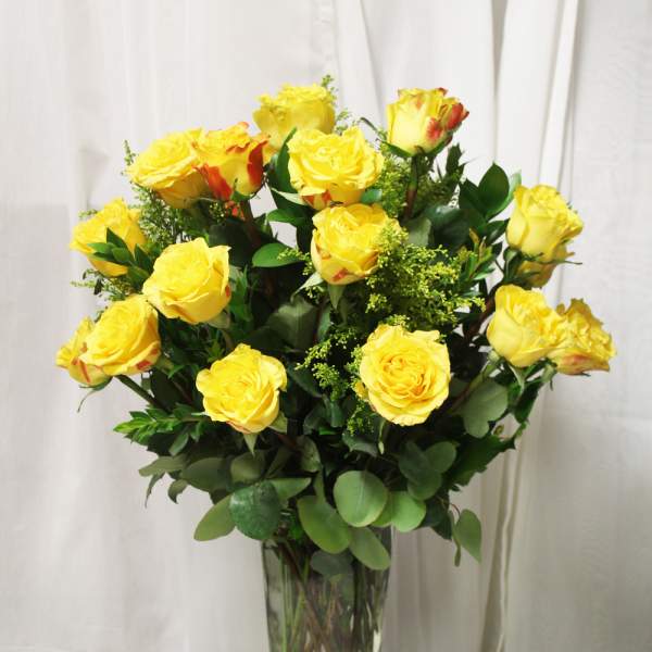 Yellow roses arranged in a clear glass vase