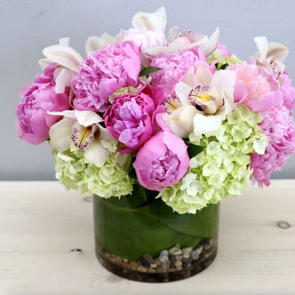 Pink peonies and white orchids in a glass vase