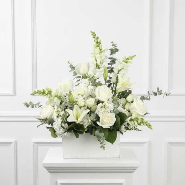 White floral arrangement in a white rectangular container
