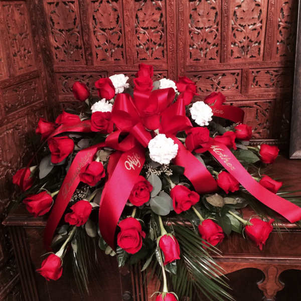 Red roses and white carnations arranged with red ribbons