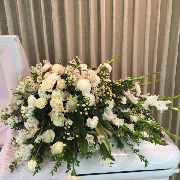 Large white floral spray arranged on a casket