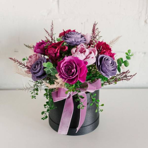 Bouquet of purple and pink roses in a black box with a lavender ribbon