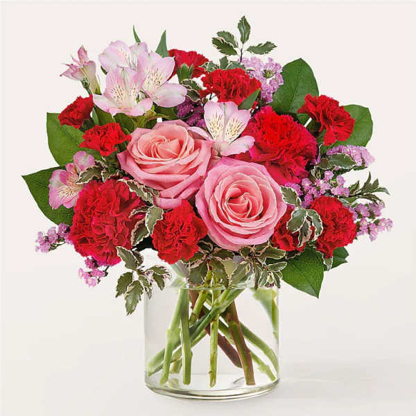 Pink roses and red carnations in a clear glass vase