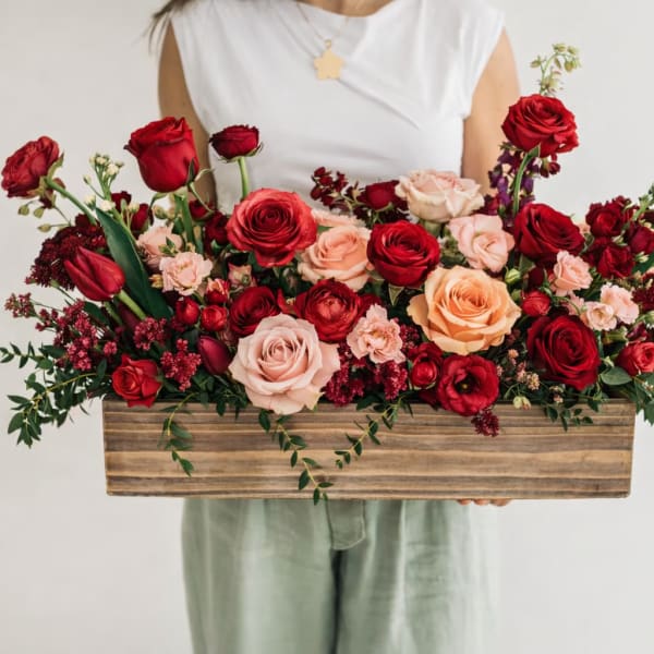 Long wooden box arrangement of red and blush roses