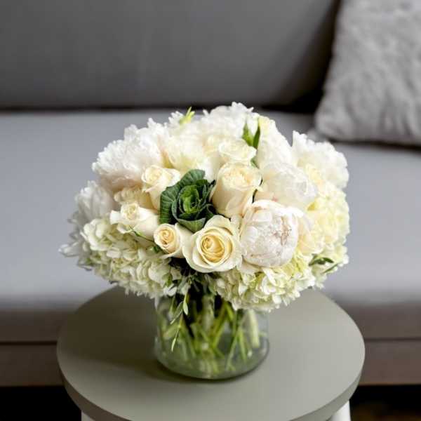 White rose and hydrangea bouquet in a clear glass vase