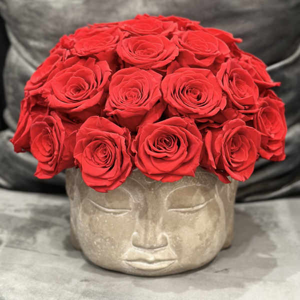 Red roses arranged in a face-shaped stone planter