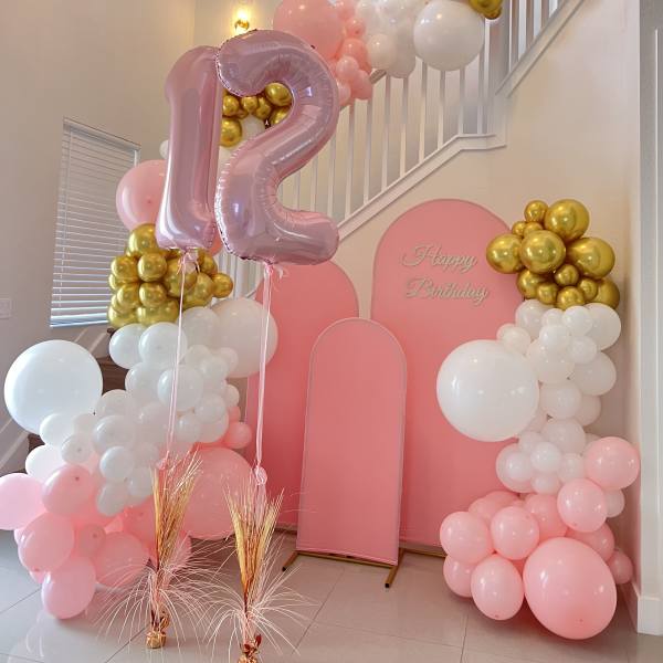 Pink and white balloon birthday display with a large number 12