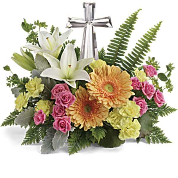Floral arrangement with white lilies, pink roses, and orange gerbera daisies around a silver cross