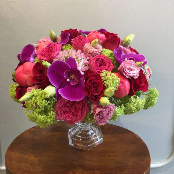 Bright mixed bouquet in a clear glass vase with purple orchids and pink roses