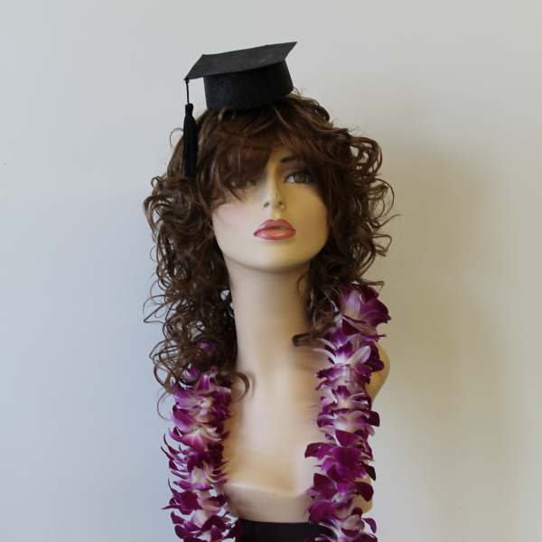 Mannequin bust wearing a graduation cap and purple orchid lei