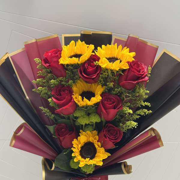 Bouquet of red roses and yellow sunflowers wrapped in black and burgundy paper
