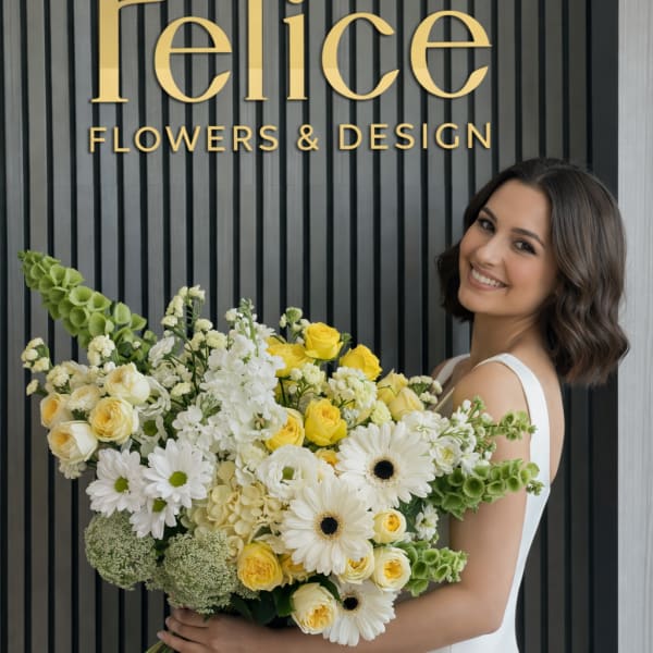 Woman holding a large bouquet of white and yellow flowers