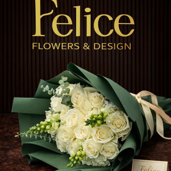 Bouquet of cream roses wrapped in dark green paper