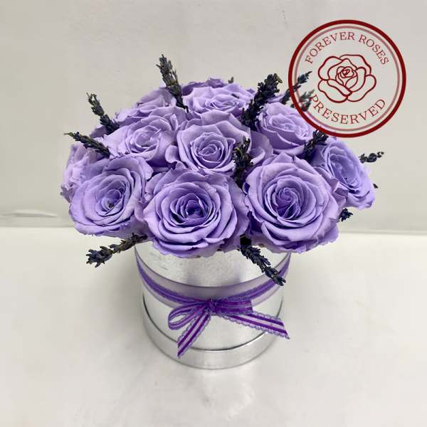 Lavender roses in a silver round box with a purple ribbon