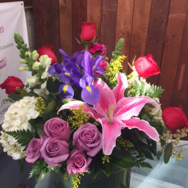 Mixed bouquet with roses, lilies, and irises in a vase