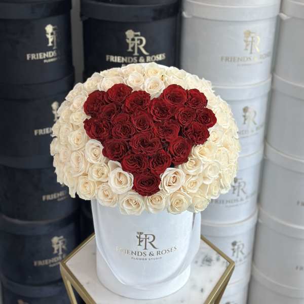 Heart-shaped red and white rose arrangement in a white hat box