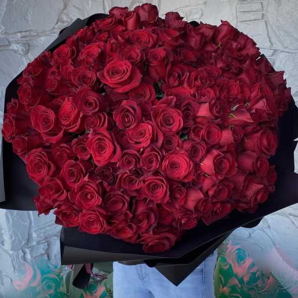 Large bouquet of red roses wrapped in black paper