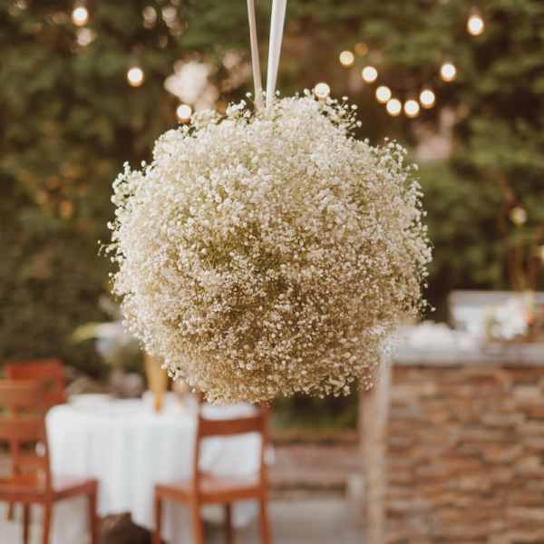 Hanging white baby's breath floral ball at an outdoor event
