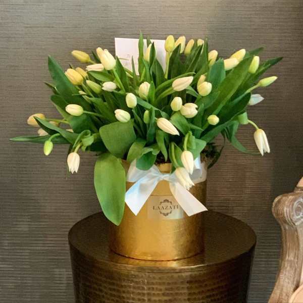 Bouquet of pale yellow tulips in a gold box tied with a white ribbon