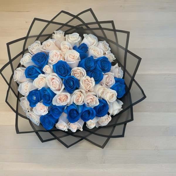 Bouquet of blue and white roses wrapped in black paper