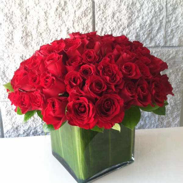 Red rose arrangement in a square glass vase