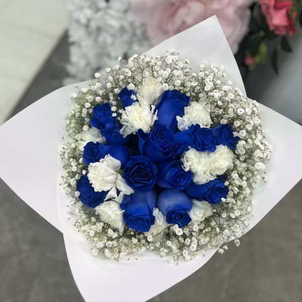 Bouquet of blue and white roses wrapped in white paper