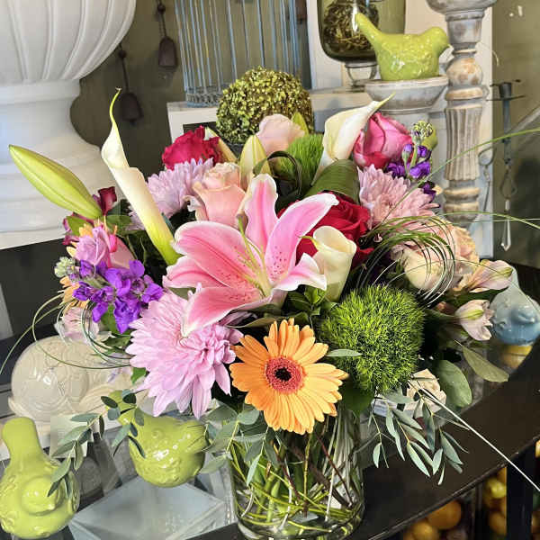 Mixed bouquet with pink lily, roses, gerbera daisy, and calla lilies in a glass vase