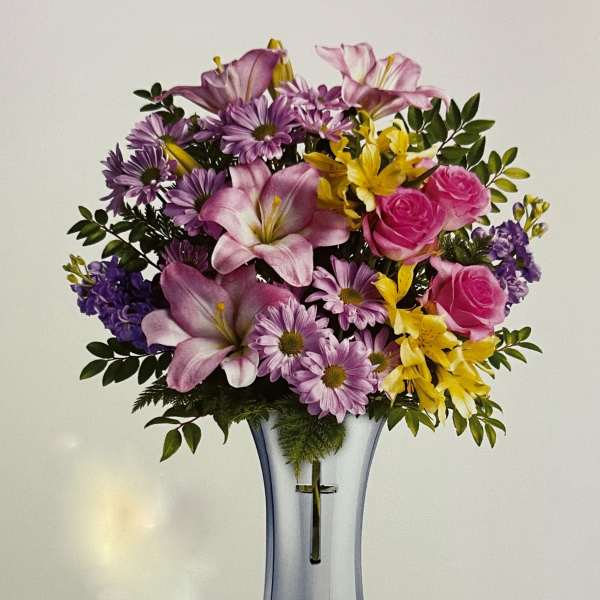 Bouquet of pink, purple, and yellow flowers in a clear glass vase